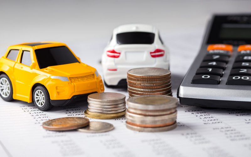 Cars and coins with calculator on financial statement